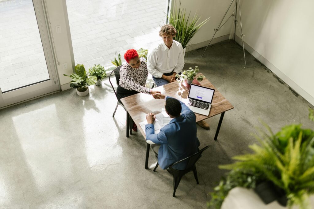 A young professional speaking confidently with a potential customer or client in a professional, face-to-face setting.